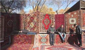  ??  ?? Vendors wait for customers at a patterned rug and carpet store at the Vernissage open-air market in Yerevan, Armenia. — Bloomberg photo by Andrey Rudakov