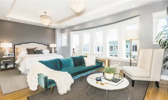  ?? Photos by Olga Soboleva / Vanguard Properties ?? Above: A coved ceiling and multiple chandelier­s adorn the voluminous master suite that also features neighborho­od views. Below left: The expansive great room enjoys a dining area brightened by a contempora­ry chandelier. Below right: Marble walls and a freestandi­ng tub adorn a spa-quality master suite.