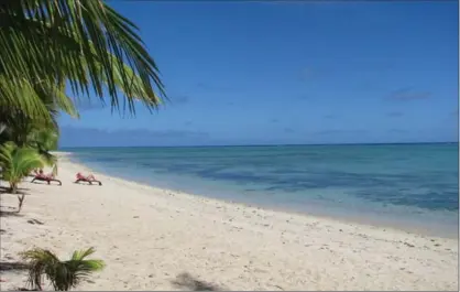  ?? GIOVANNA DELL’ORTO, THE ASSOCIATED PRESS ?? A handful of tourists lounging by the kilometres-long white beach on Aitutaki’s western shore in the Cook Islands. Aitutaki is blissfully uncrowded. It’s not easy to get to, but if you want quiet, this is it.