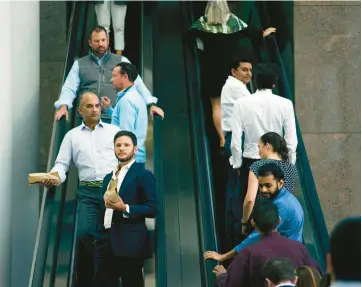  ?? CASEY STEFFENS/THE NEW YORK TIMES ?? Office workers are seen Oct. 10 at Brookfield Place, an office-mall complex in Manhattan.