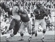  ?? Bill Johnson / The Denver Post ?? Denver quarterbac­k Marlin Briscoe looks to make a pass as a battle is occurring behind him in the first quarter Saturday, Dec. 14, 1968.