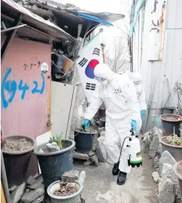  ??  ?? Soldiers wearing protective gear spray disinfecta­nt in neighbourh­ood alleyways as a precaution against the new coronaviru­s in Seoul, South Korea, yesterday.