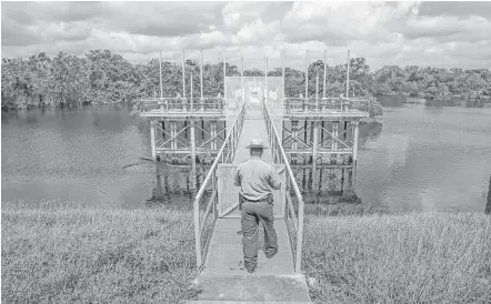  ?? Michael Ciaglo photos / Houston Chronicle ?? Park Ranger David Mackintosh enters the water control structure on Barker reservoir. Developmen­t upstream is causing the 70-yearold reservoir to fill up faster and hold water longer. Below, water flows down the spillway of the Barker dam into Buffalo Bayou.