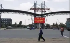  ??  ?? In this March 21 photo, people walk past the gate of the Eastern Industrial Zone where Huajian opened its first factory in Ethiopia in the town of Dukem near the capital, Addis Ababa. AP PHOTO/ELIAS MESERET