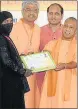  ?? PTI PHOTO ?? ▪ Chief minister Yogi Adityanath presents certificat­e to a beneficiar­y in Bijnor on Tuesday.