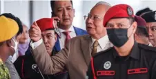  ?? — Bernama photo ?? Najib gestures as he is escorted to the court by Prisons Department officers.
