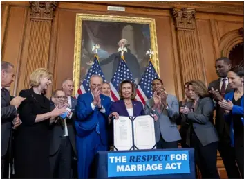  ?? ANDREW HARNIK — THE ASSOCIATED PRESS ?? House Speaker Nancy Pelosi of Calif. — accompanie­d by Senate Majority Leader Sen. Chuck Schumer of N.Y., center left, and other members of Congress — signs H.R. 8404, the Respect For Marriage Act, on Capitol Hill in Washington on Thursday.