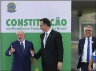  ?? (AP/Eraldo Peres) ?? Brazilian President Luiz Inacio Lula da Silva (left) and Senate President Rodrigo Pacheco pose Monday in front of a replica of their nation’s constituti­on outside Congress in Brasilia, Brazil, after a ceremony marking the one-year anniversar­y since rioters stormed government buildings in support of former President Jair Bolsonaro.