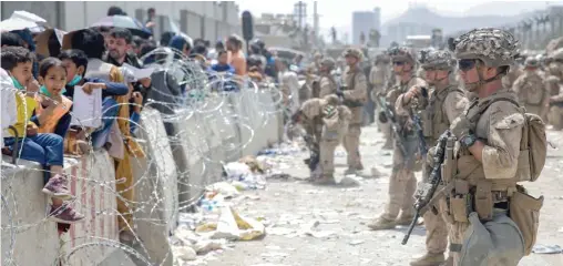  ??  ?? U.S. Marines provide security and assistance on Friday during the ongoing evacuation at Hamid Karzai Internatio­nal Airport in Kabul, Afghanista­n.