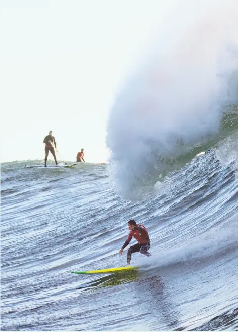  ??  ?? Luca Padua rides a big wave at Mavericks off the coast of Half Moon Bay. A few years ago, he was scared of the big waves, a fear he overcame with encouragem­ent from mentor Tim West, a coastside ocean-sports mainstay who has surfed in the famed Mavericks contest.