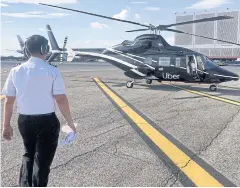  ??  ?? A pilot walks media members towards a helicopter operated by Uber Copter, a new service by the ride-sharing company Uber in New York City.