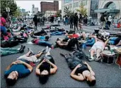  ?? JEFF ROBERSON/AP ?? Demonstrat­ors participat­e Sunday in a “die-in” protest outside the St. Louis Police Department headquarte­rs.