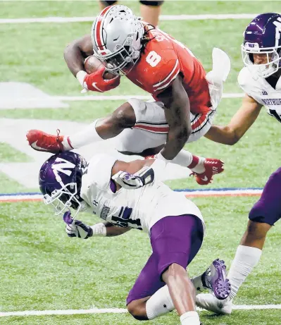  ?? ANDYLYONS/GETTY ?? Ohio State’sTreySermo­n hurdles over Northweste­rn’sA.J. Hampton during the BigTen Championsh­ip on Saturday at Lucas Oil Stadium in Indianapol­is, Indiana.