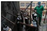  ?? (AP/Anupam Nath) ?? A health worker checks oxygen cylinders Thursday next to a train that’s being used as a covid-19 care center in Gawahati, India. Demand for oxygen has increased sevenfold there in the past month as coronaviru­s cases rise across India.