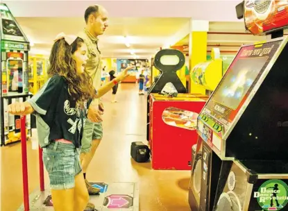  ?? BRUCE DEACHMAN/OTTAWA CITIZEN ?? Twelve-year-old Lauren Davis and her uncle Kelvin Davis bust a few moves on Dance Dance Revolution recently at Midway.