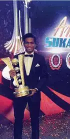  ??  ?? Syafiq menunjukka­n piala dimenangi pasukan hoki kebangsaan bagi kategori berpasukan bersempena Anugerah Sukan Negara 2017 di Kuala Lumpur.