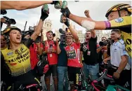  ??  ?? George Bennett, left, joins in the celebratio­ns after Primoz Roglic, centre, won the Vuelta a Espana.