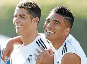  ??  ?? All smiles: Cristiano Ronaldo (left) and Carlos Henrique Casimiro share a joke before Real Madrid’s training session at the University of California Los Angeles (UCLA) on Monday. — AFP