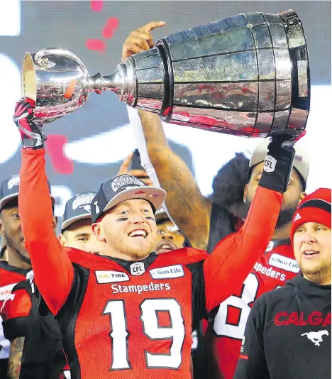  ?? GAVIN YOUNG ?? Calgary Stampeders quarterbac­k Bo Levi Mitchell raises the Grey Cup for a second time in his career after defeating the Ottawa Redblacks at Commonweal­th Stadium in Edmonton on Sunday. Mitchell threw for 253 yards and a pair of touchdowns in the victory.