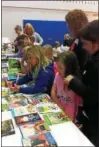  ??  ?? Students happily selecting a free book or two to take home.