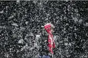  ?? MATT ROURKE / AP ?? A woman walks through a winter snow storm in Philadelph­ia on Friday. Meteorolog­ists forecast a blizzard watch for coastal regions including New York City and Boston beginning Monday night.