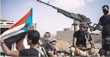  ??  ?? Shabwani Elite Forces fighters in Azzan display the flag of South Yemen, which ceased to exist in 1990.