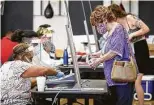  ?? Steve Gonzales / Staff photograph­er ?? Voters check in Tuesday at the Metropolit­an Multi-Services Center on West Gray.