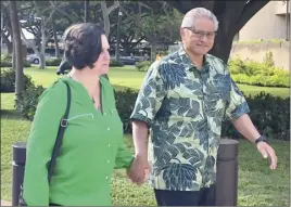  ?? AP file photo ?? Retired Honolulu police chief Louis Kealoha and his wife, former deputy city prosecutor Katherine Kealoha, hold hands while walking to U.S. district court in Honolulu in 2019. The once-respected, now-estranged power couple were sentenced Monday to prison terms for corruption.