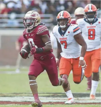  ?? PHIL SEARS/AP ?? Florida State running back Treshaun Ward (8) is trailed by Syracuse linebacker Stefon Thompson (7) as he runs for 65 yards in the fourth quarter of a game on Oct. 2, 2021, in Tallahasse­e. Florida State won 33-30.
