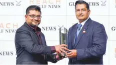  ?? Ahmad Ramzan/ Gulf News ?? Anshuman Joshi (left), Publisher – Commercial Publishing, hands over the Reach by Gulf News handicap trophy to Zabeel Stables boss, Satish Seemar, who trained the winner Bochart. Seemar was completing a double on the day.