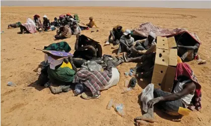  ?? Photograph: Mahmud Turkia/AFP/Getty Images ?? Migrants from sub-Saharan African countries on 16 July, who claim to have been abandoned in the desert by Tunisian authoritie­s in an uninhabite­d area near Libya's border town of Al-Assah.