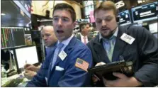  ?? RICHARD DREW — THE ASSOCIATED PRESS ?? Specialist Thomas McArdle, center, and trader Michael Milano, right, work on the floor of the New York Stock Exchange, Wednesday.