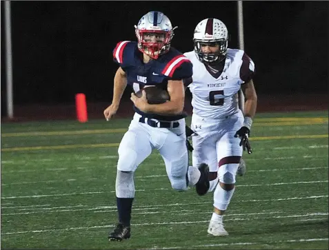  ?? Photo by Ernest A. Brown ?? Lincoln junior running back Tyler Dusty is on the move as he carries the ball while Woonsocket’s Jaiden Milatmouk (6) is in hot pursuit during first-quarter action at Ferguson Field on Friday night. Dusty scored a 73-yard rushing touchdown in the third quarter as the Lions opened Division II play with a 26-0 win over the defending Super Bowl champs.