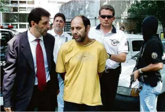  ?? Paulo Whitaker - 4.fev.02/Reuters ?? Maurício Hernandez Norambuena, de amarelo, ao ser preso em 2002