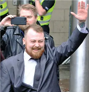  ??  ?? Defiant: Mark Meechan waves to supporters outside court yesterday