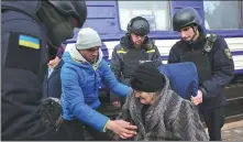  ?? ANATOLII STEPANOV / AFP ?? Ukrainian emergency service employees help a resident board an evacuation train in Donetsk on Saturday.