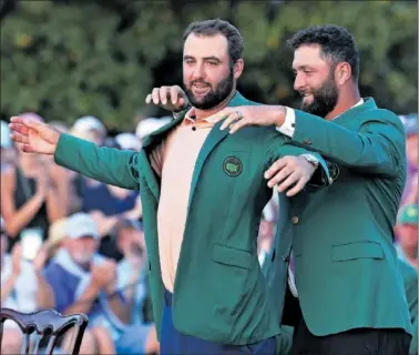  ?? ?? Jon Rahm le coloca la chaqueta verde de campeón a Scottie Scheffler.