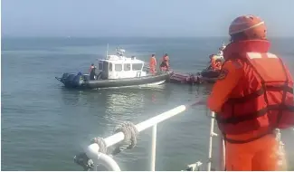  ?? ?? Taiwanese coast guards inspect a vessel that capsized during a chase off the coast of Kinmen archipelag­o in Taiwan, Feb. 14, 2024.