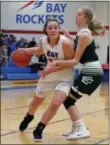  ?? RANDY MEYERS — FOR THE MORNING JOURNAL ?? Maeve Johnston of Bay drives by Emily Rapacz of Elyria Catholic during the second quarter on Jan. 5.