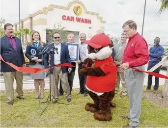  ?? Craig Moseley/Staff file photo ?? Katy City Council Member Steve Pierson assists Buc-ee the Beaver as he cuts a ribbon at the November 2017 ceremony designatin­g the car wash at the Katy site as a Guinness World Record.