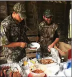  ?? Arkansas Democrat-Gazette/BRYAN HENDRICKS ?? Dove hunters refuel after a hot morning with barbecue and cornbread.