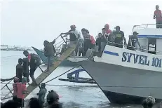  ?? DJ KYLE/THE ASSOCIATED PRESS ?? Rescued passengers from the ill-fated M/V Mercraft 3 disembark from a boat which helped in the rescue operation at Infanta township, Quezon province in the northeaste­rn Philippine­s on Thursday.