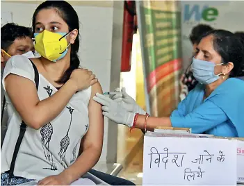  ?? —
PTI ?? A beneficiar­y receives a dose of Covid-19 vaccine during a vaccinatio­n camp for students and citizens at a polyclinic in Gurugram on Tuesday.