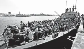  ?? MAHMUD TURKIA, AFP/GETTY IMAGES ?? Illegal immigrants, who were rescued by the Libyan coast guard in the Mediterran­ean off the Libyan coast, arrive at a naval base in the capital Tripoli on Wednesday.