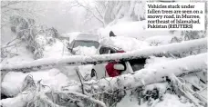  ?? ?? Vehicles stuck under fallen trees are seen on a snowy road, in Murree, northeast of Islamabad, Pakistan (REUTERS)