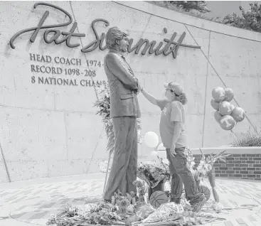  ?? Caithe McMekin / Associated Press ?? Teresa Olive of Knoxville visits a statue of Pat Summitt that fittingly stands tall on the Tennessee campus.