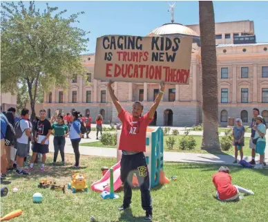  ??  ?? Kyle James, outside of the Arizona Capitol on Tuesday, protests against Trump immigratio­n policy.