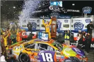  ?? STEVE HELBER ?? Kyle Busch, center, celebrates Sunday under the lights after winning the NASCAR Cup race at Martinsvil­le Speedway in Martinsvil­le, Va.