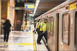  ?? Brian van der Brug Los Angeles Times ?? METRO AMBASSADOR­S, who are not armed, board a B Line train at the Universal City subway station on July 24 in Los Angeles.