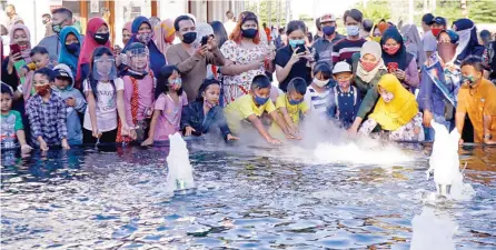  ?? DIPTA WAHYU/JAWA POS ?? SALAH SATU SPOT FAVORIT: Orang dewasa dan anak-anak menyemut di lokasi air mancur kemarin.